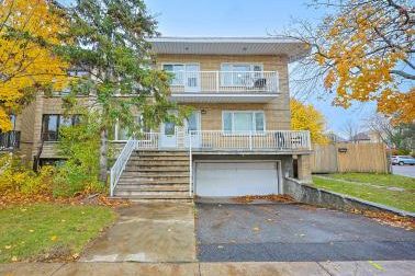 Duplex de brique blonde à Côte-Saint-Luc, garage attenant et érables aux feuilles jaunes